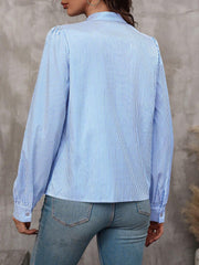 Light blue striped blouse with puffed sleeves and button cuffs.