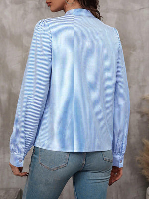 Light blue striped blouse with puffed sleeves and button cuffs.