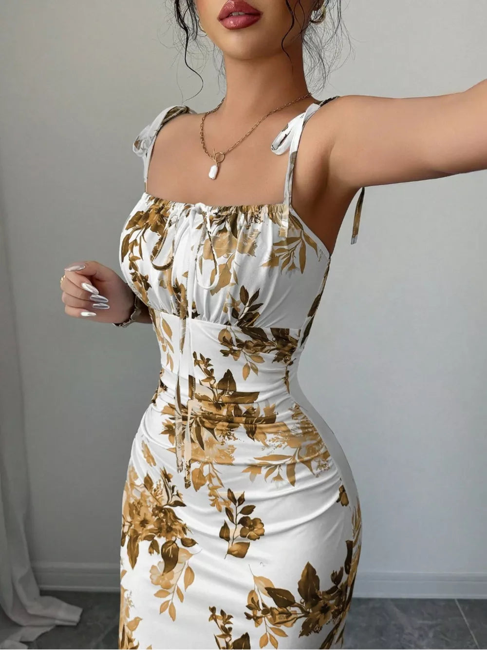 Floral print tie strap maxi dress in white with brown floral pattern, ruched bodice and square neckline.