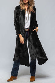 Black velvet duster coat with dramatic split back and open front, styled with jeans.