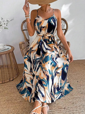 Vibrant abstract print cami maxi dress with a belted waist and v-neckline.