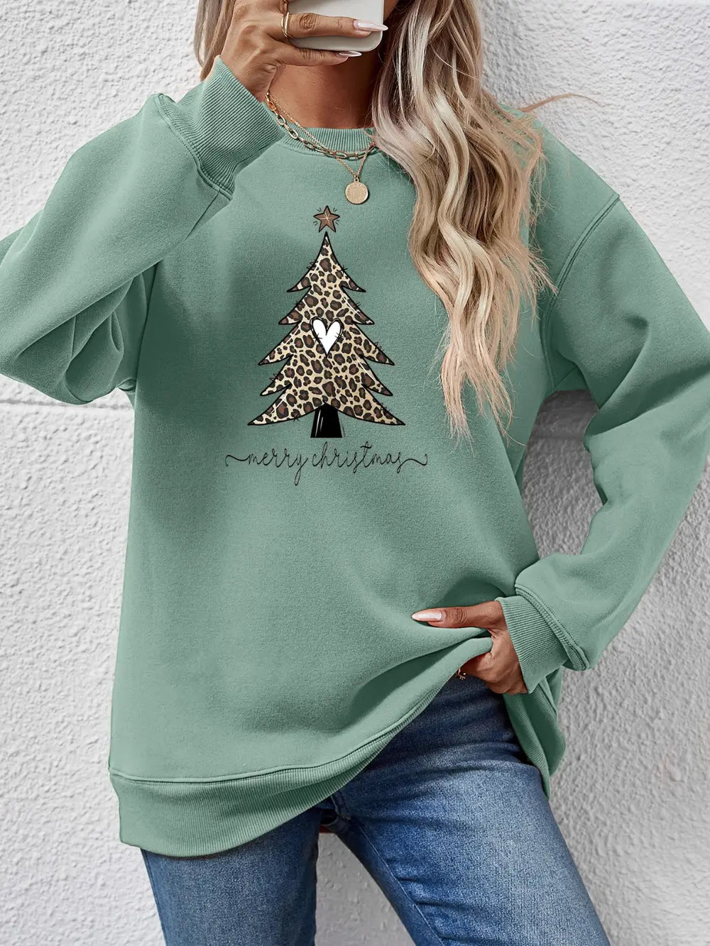 Sage green sweatshirt with leopard print Christmas tree graphic and merry christmas text