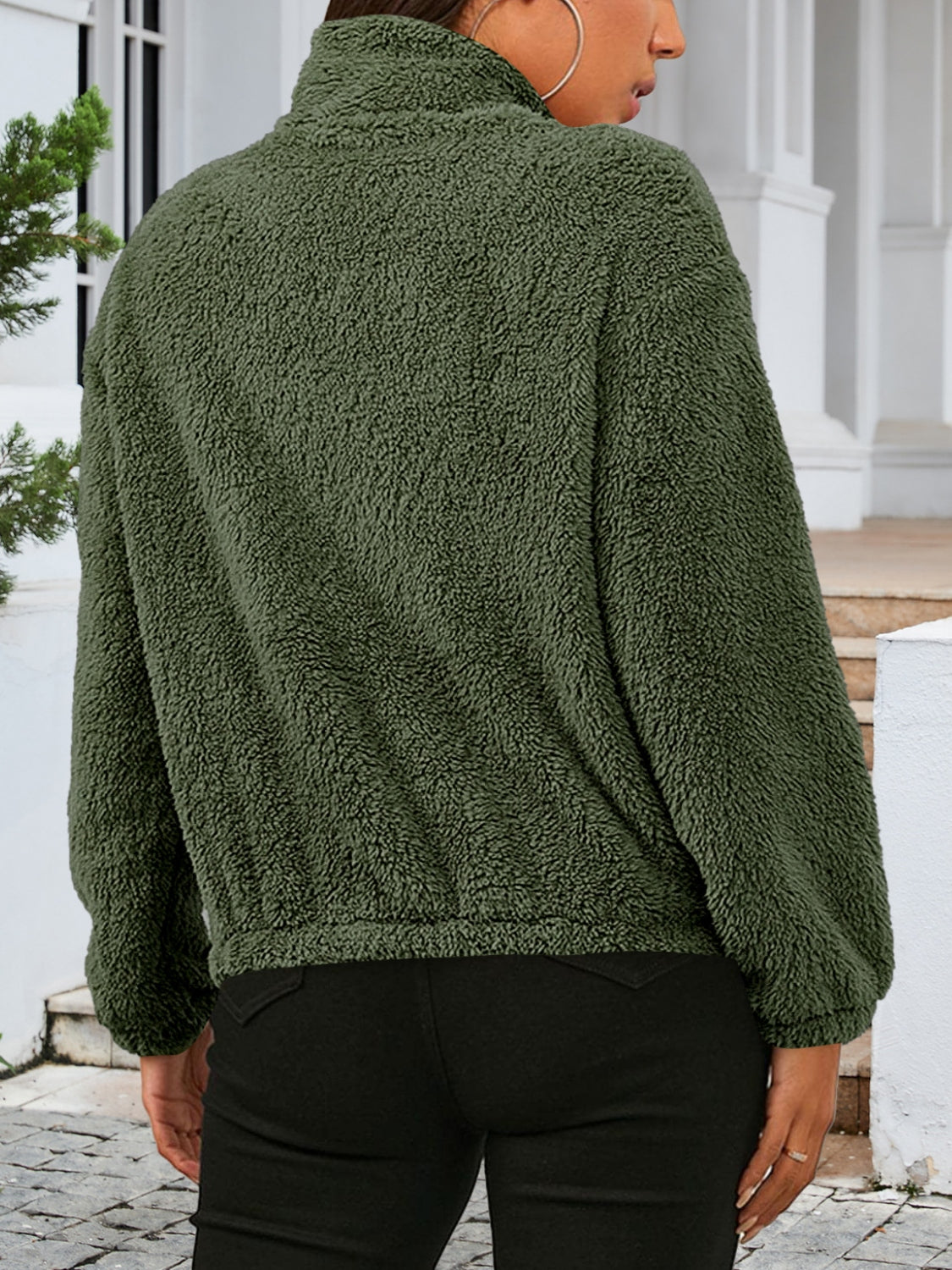 Green sherpa bomber jacket with a stand-up collar and elastic cuffs.
