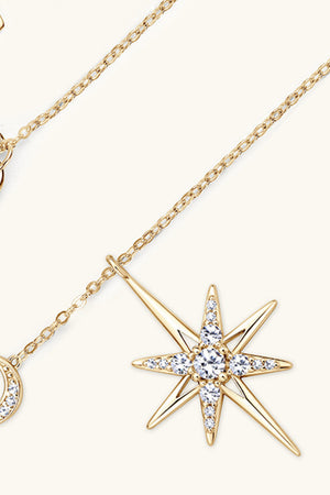Gold celestial starburst pendant necklace with clear crystals on a delicate chain.