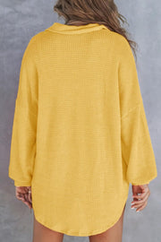 Gold waffle knit henley shirt with collar and long sleeves.