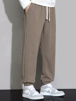 Brown cuffed ankle joggers with drawstring waist and side seams.