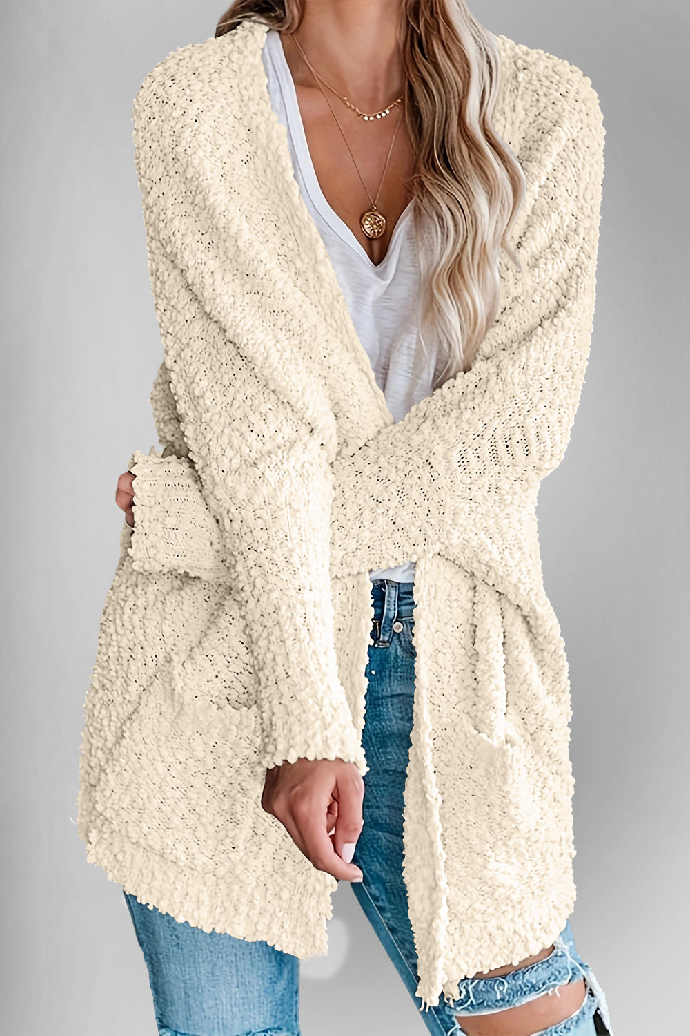 Cream popcorn knit open cardigan with pockets and a relaxed fit.