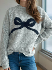 Gray knit sweater with a navy intarsia bow design and mock neckline.