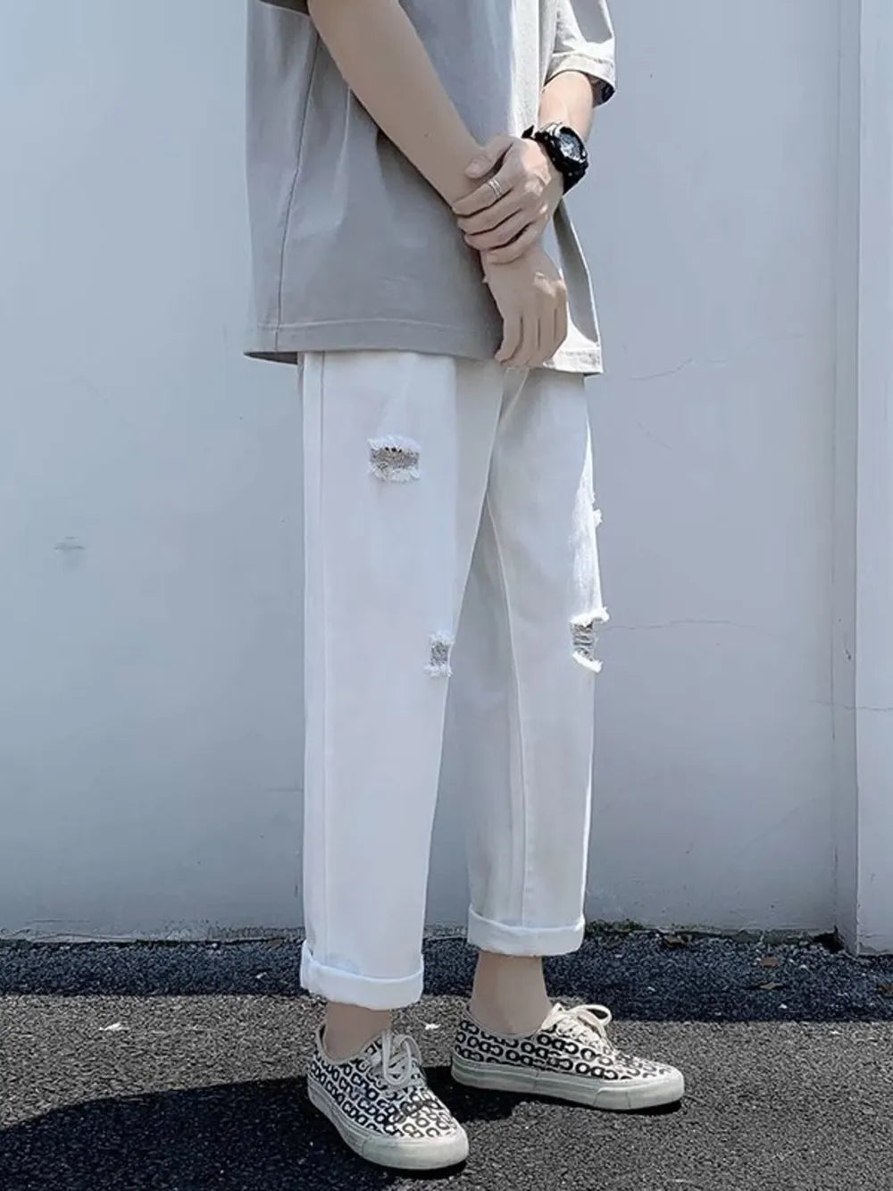 White relaxed fit men's jeans with distressed details and cuffed hem