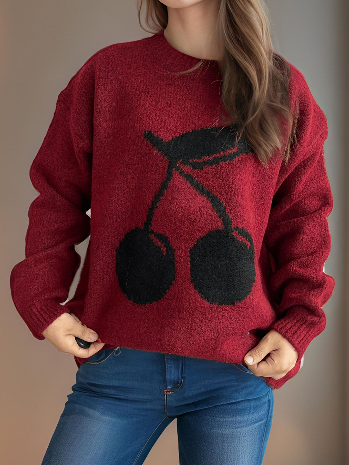 Burgundy knit sweater with black cherry motif, crew neck, long sleeves.