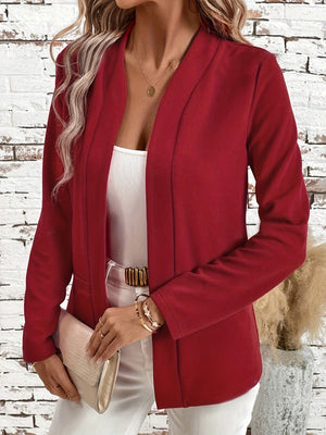 Open-front rust blazer with clean lines and long sleeves, worn over a white top.