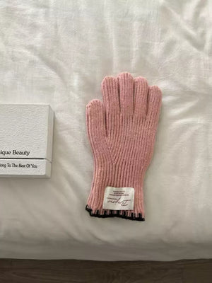 Pink ribbed knit gloves with scalloped black cuff detail and label