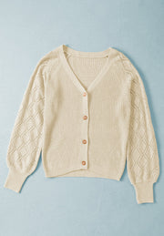 Cream diamond-cut sleeve knit cardigan with V-neck and button front.