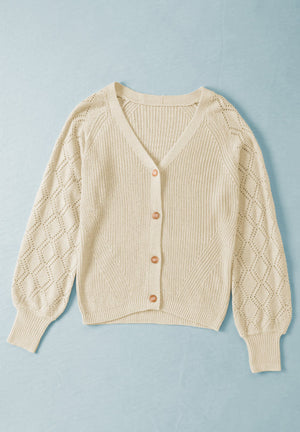 Cream diamond-cut sleeve knit cardigan with V-neck and button front.
