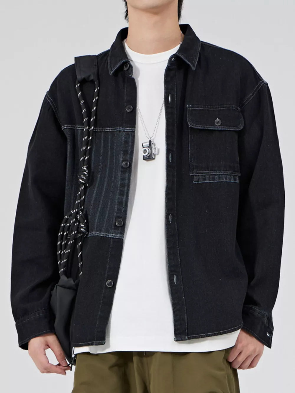 Men's black denim overshirt with chest pockets and contrast panel detail.
