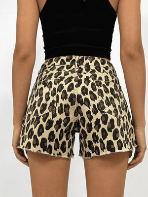 Leopard print high-waisted denim shorts with raw hem and button closure.