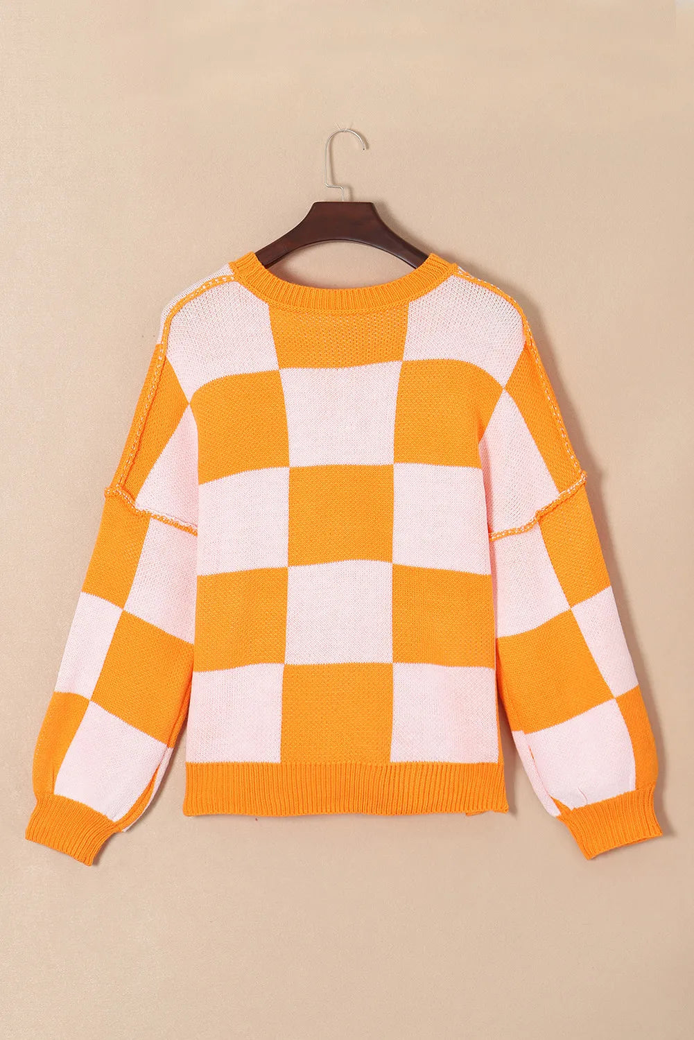 Checkerboard pumpkin appliqué knit sweater in tangerine with crewneck and long sleeves.