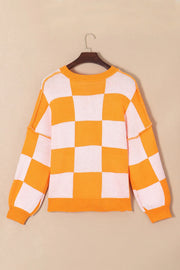 Checkerboard pumpkin appliqué knit sweater in tangerine with crewneck and long sleeves.