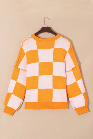 Checkerboard pumpkin appliqué knit sweater in tangerine with crewneck and long sleeves.