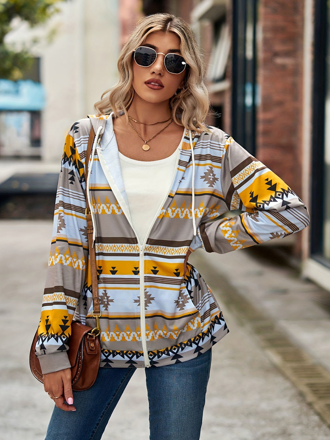 Aztec print zip-up hooded jacket in gray with yellow, blue, and brown geometric patterns.
