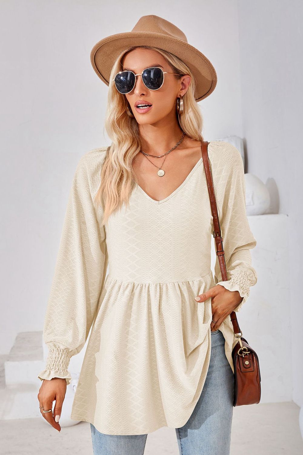 Cream textured babydoll blouse with v-neck and smocked cuffs