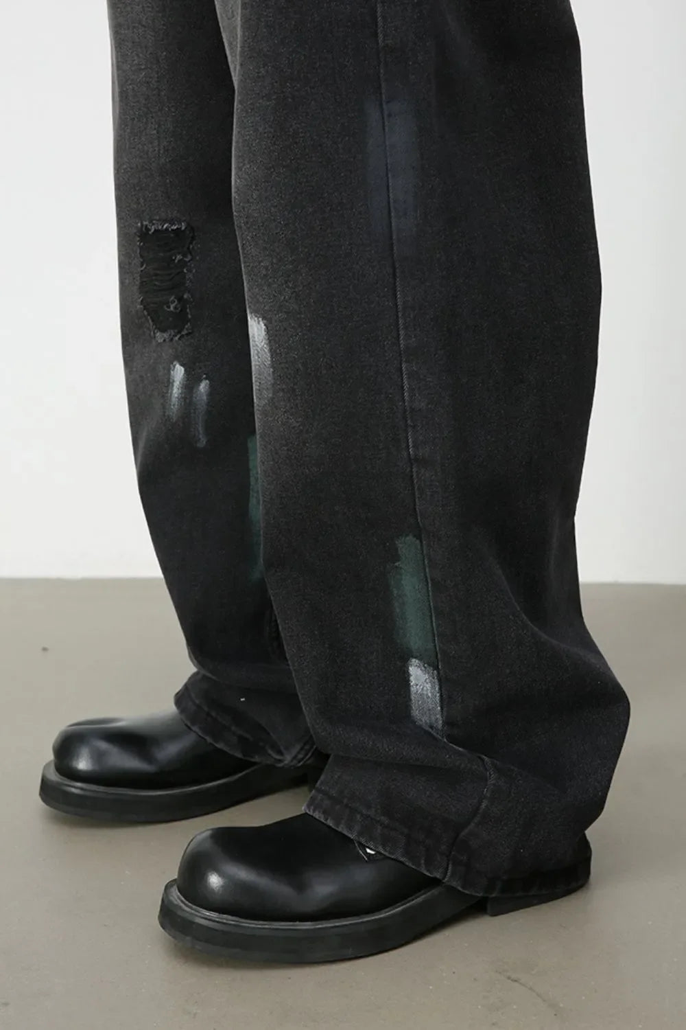Dark wash wide-leg jeans with distressed details and painterly brushstrokes.
