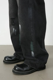 Dark wash wide-leg jeans with distressed details and painterly brushstrokes.
