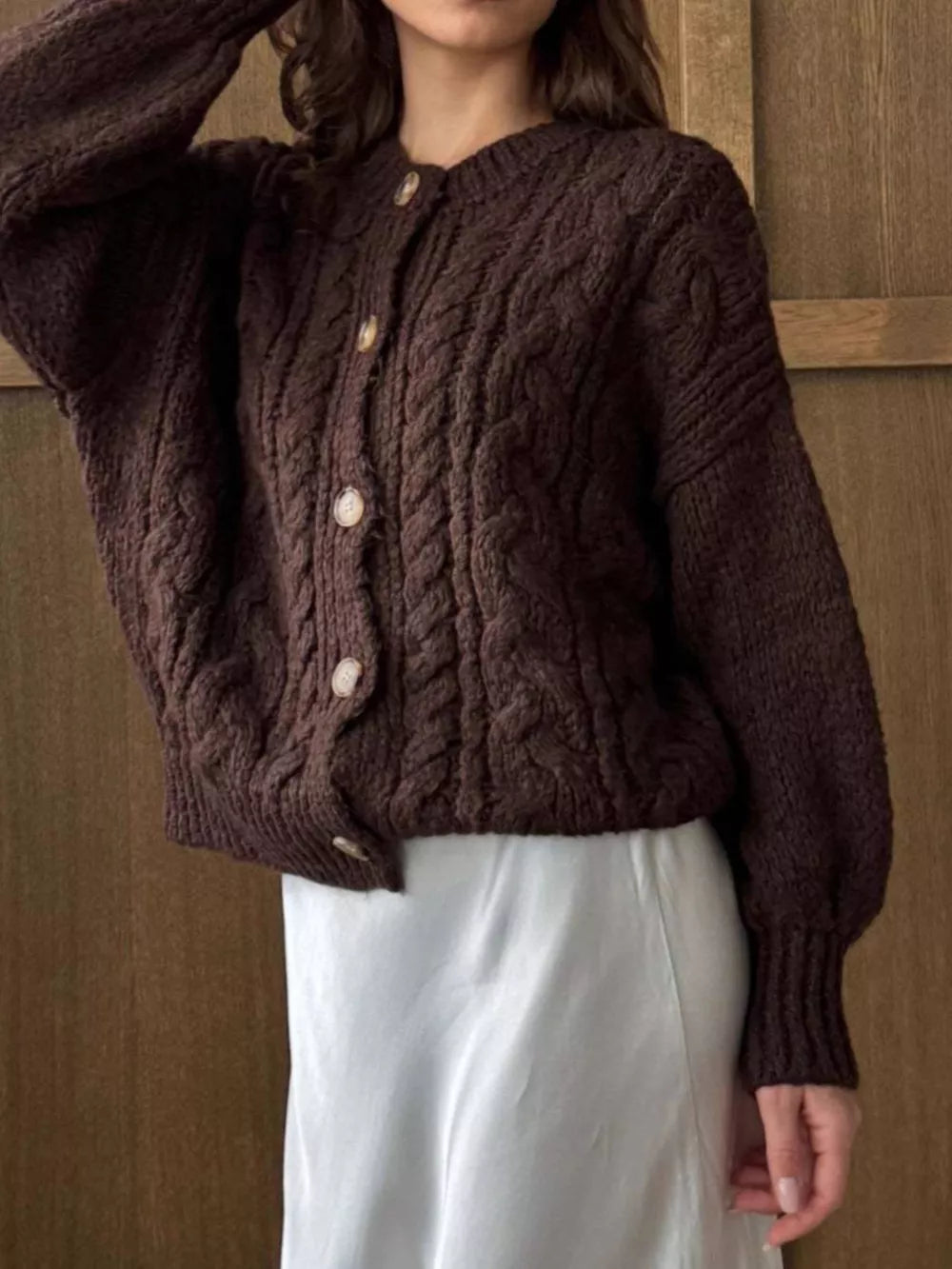 Brown cable-knit button-down cardigan with crew neck and balloon sleeves.