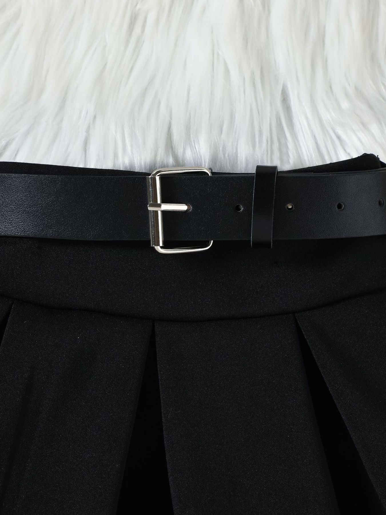 Black pleated skirt with a faux leather belt and silver buckle detail