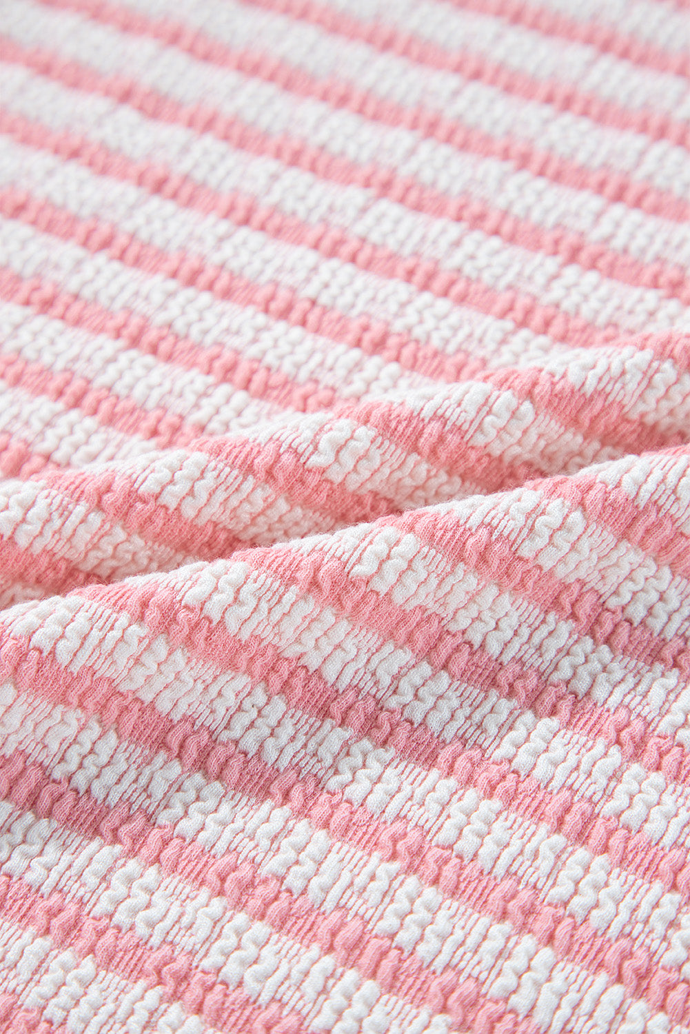 Textured stripe puff sleeve top in blush pink with a seersucker fabric detail.
