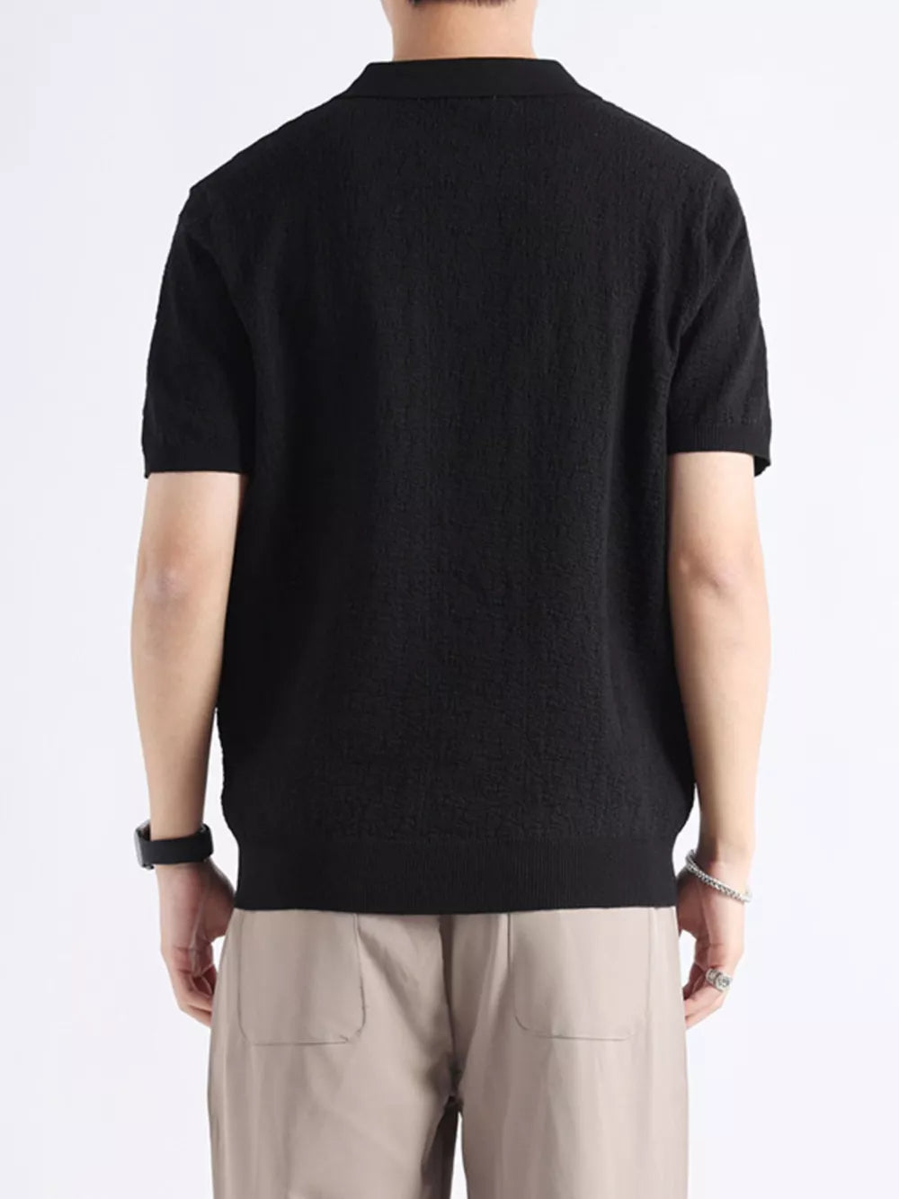 Black short-sleeve polo shirt with textured fabric and classic collar.