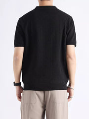 Black short-sleeve polo shirt with textured fabric and classic collar.