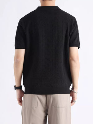 Black short-sleeve polo shirt with textured fabric and classic collar.