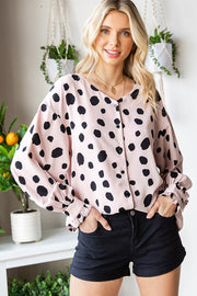 Beige polka dot blouse with balloon sleeves and ruffled cuffs, buttoned front.