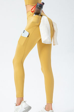 Gold athletic leggings with utility pockets, phone pocket, and towel detail.
