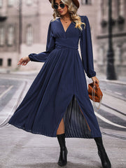Dark blue pleated maxi dress with crossover waist and thigh-high slit.