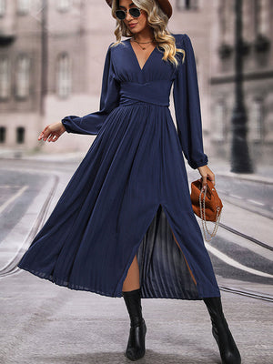 Dark blue pleated maxi dress with crossover waist and thigh-high slit.