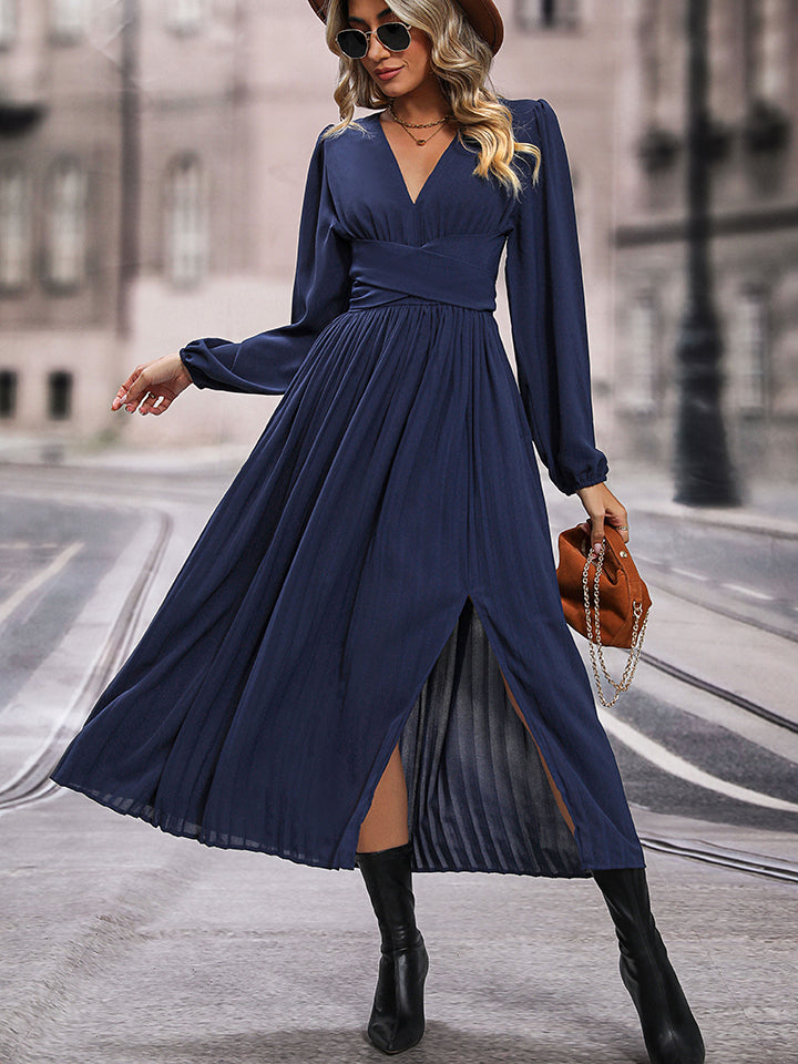 Dark blue pleated maxi dress with crossover waist and thigh-high slit.