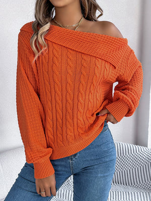 Orange off-shoulder cable knit pullover sweater with asymmetrical neckline.