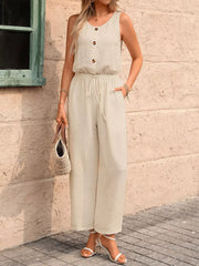 Khaki wide-leg romper with button detail, drawstring waist, and textured fabric.