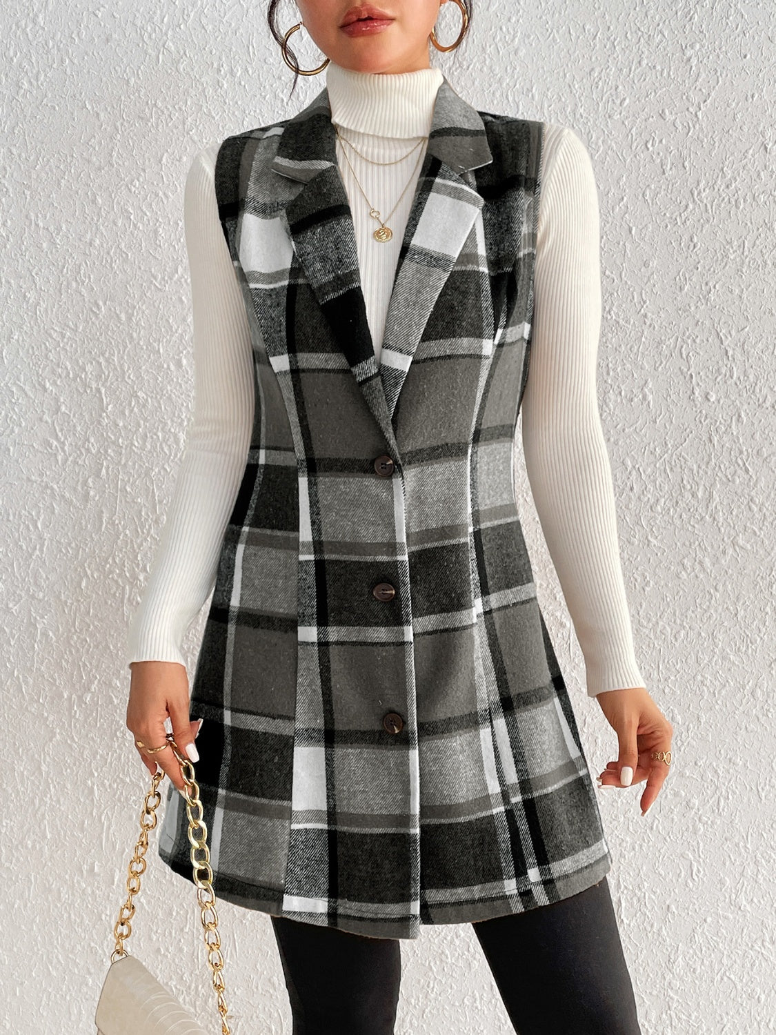 Sleeveless plaid blazer dress in black and grey, buttoned A-line cut, worn with a white turtleneck.