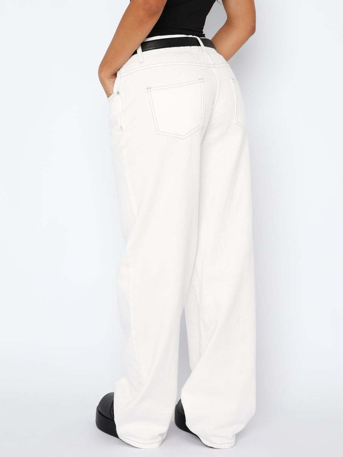 White wide-leg denim jeans with contrast stitching and a black belt.