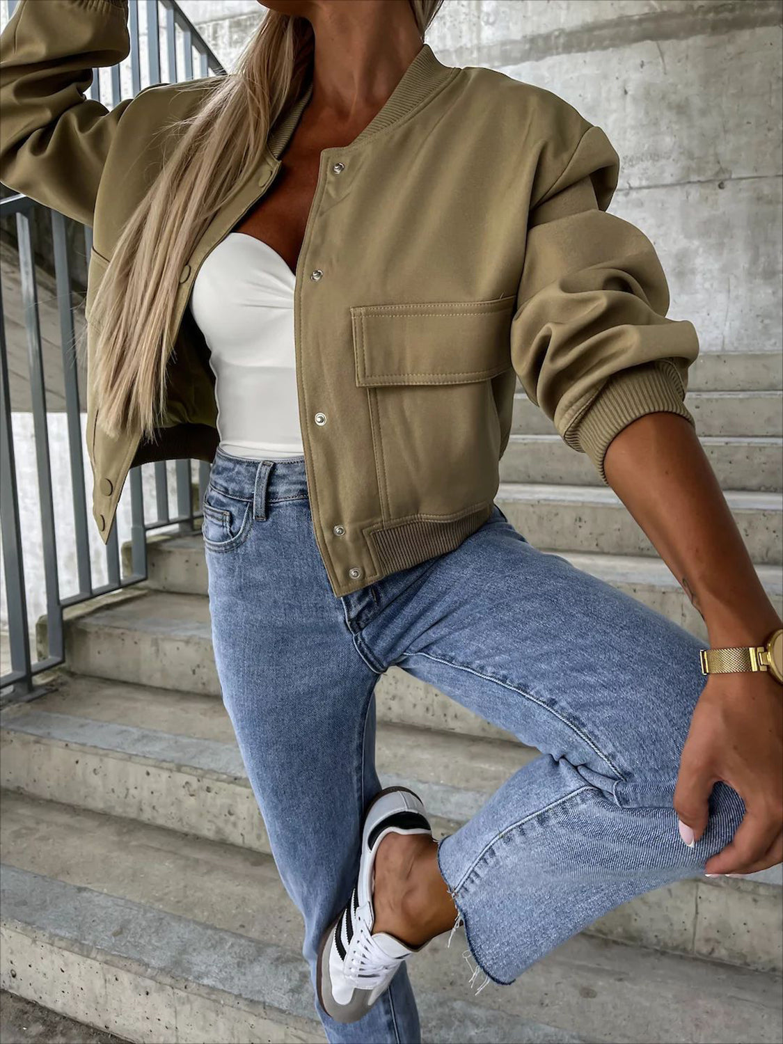 Olive bomber jacket with sculpted sleeves, snap front, and chest pockets.