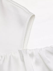 White ruffled cold shoulder maternity blouse with elasticized neckline detail.