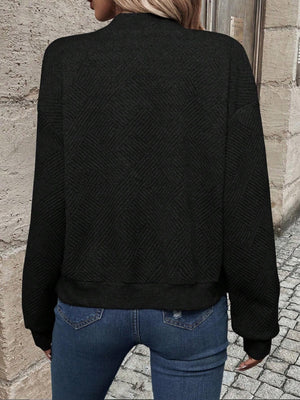 Black geometric quilted bomber jacket with a mock neck and ribbed cuffs.