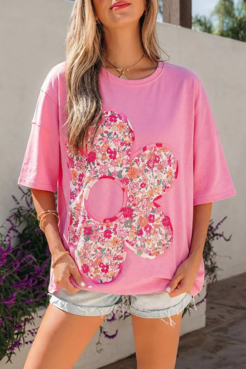 Pink cotton tunic t-shirt with oversized floral patch, crew neck, and short sleeves.