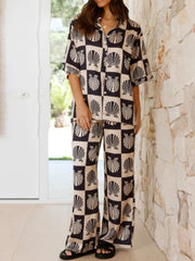 Black shell print silk pajama set with buttoned shirt and wide leg pants