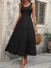 Black smocked bodice tiered maxi dress with a scoop neck and sleeveless design.
