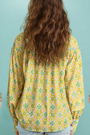 Yellow green floral ruffle yoke button-down blouse with long sleeves.