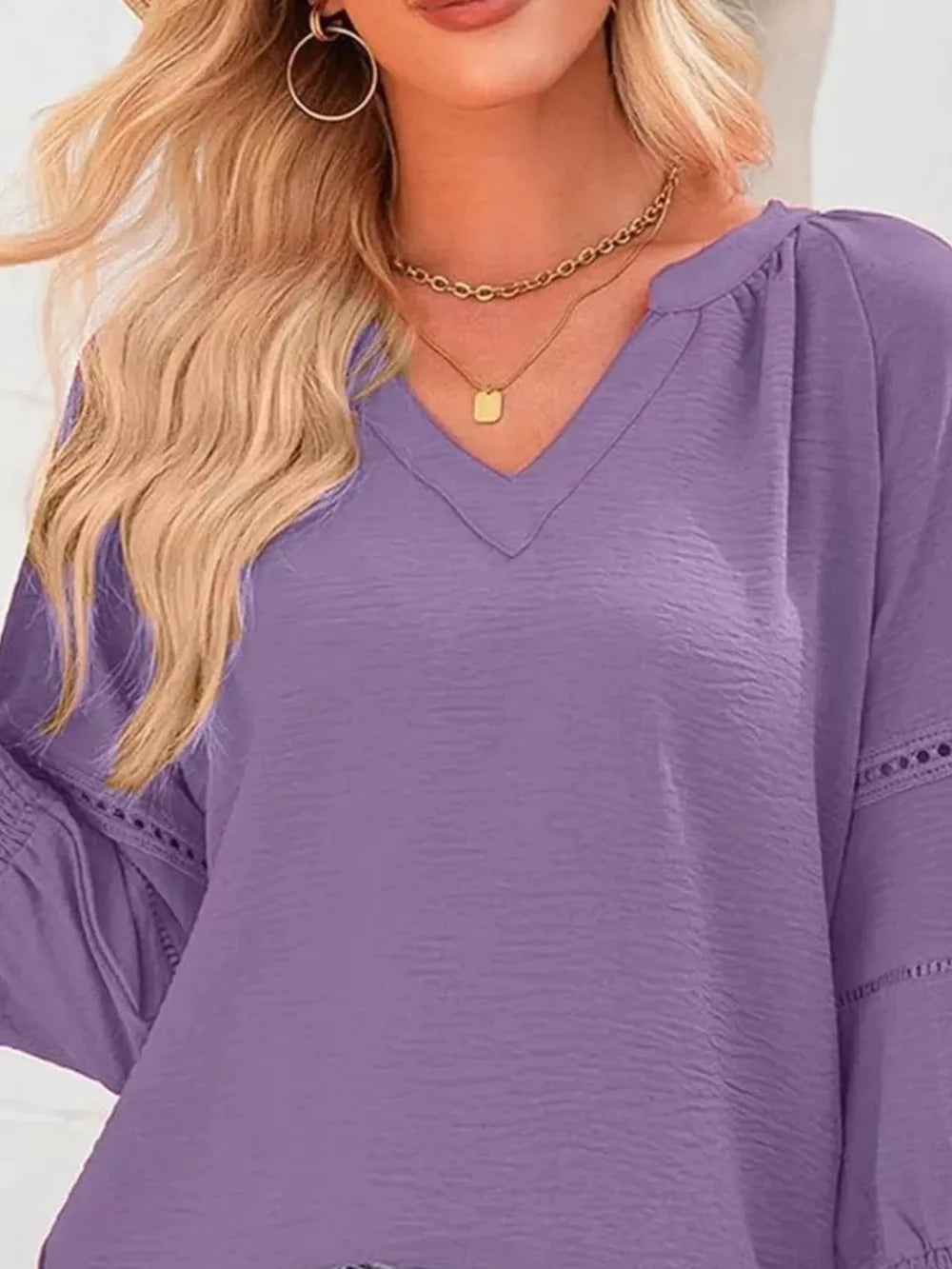 Purple polyester blouse with V-neck, smocked details, and eyelet trim on sleeves.